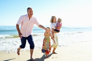 Familia feliz corriendo en la playa